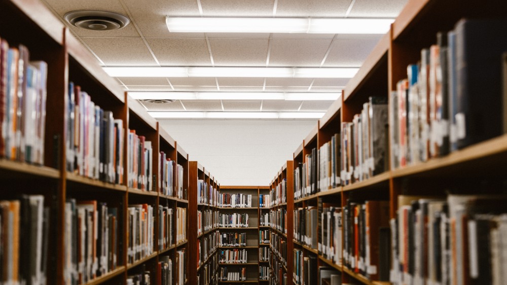 一幅图书馆的图片，书架上一排排的书清晰可见